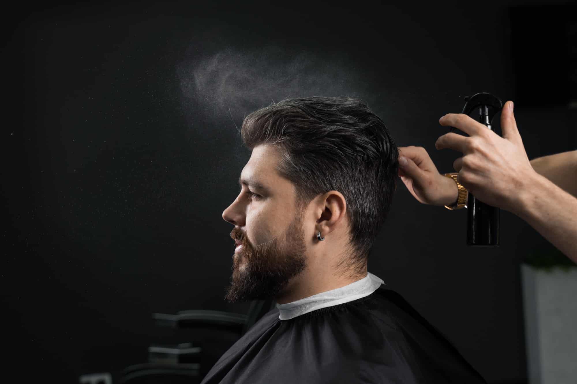 Barber making hairstyle for confident bearded hipster. Advertising for barbershop and men's beauty salon.